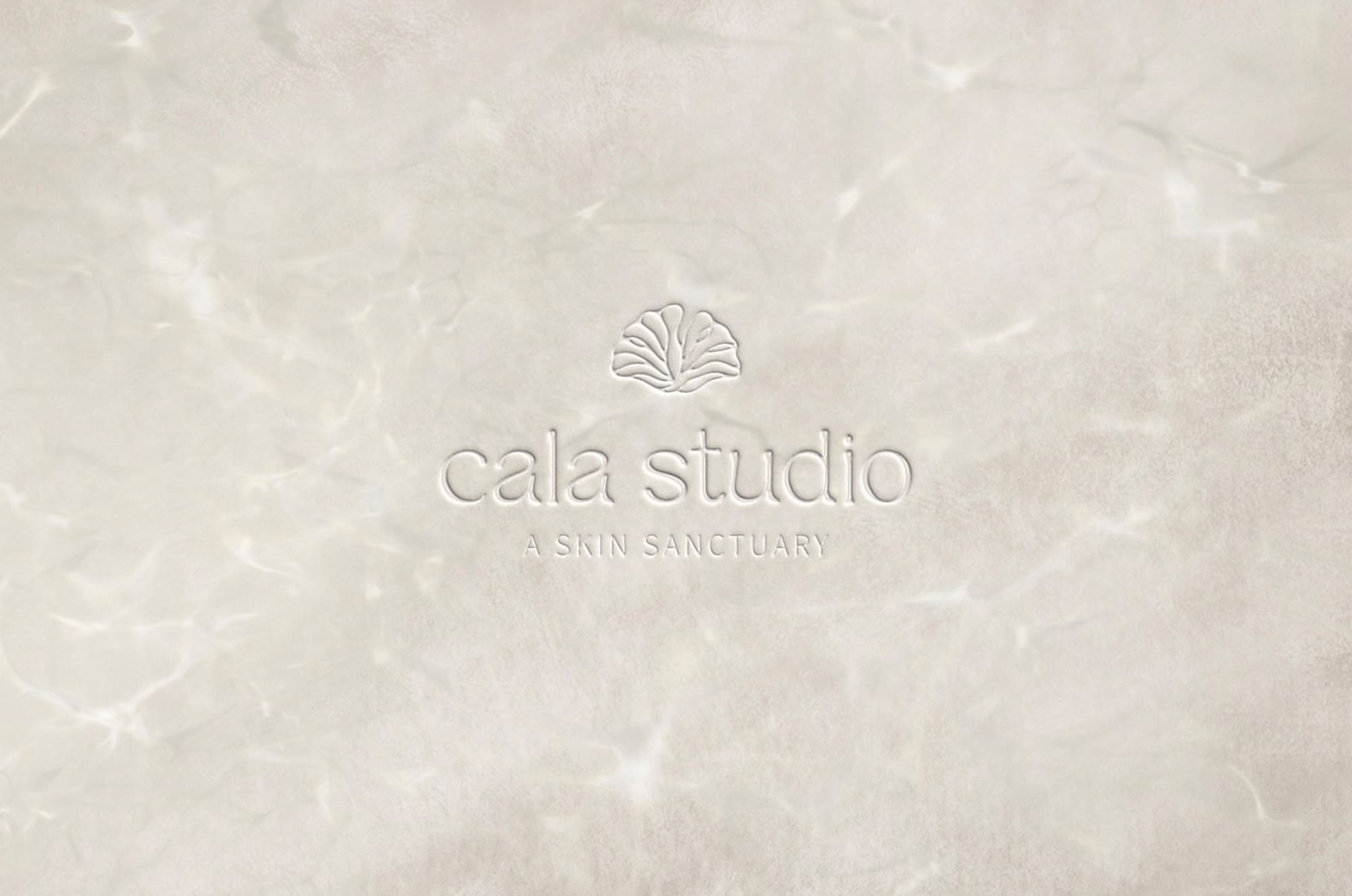 Embossed primary logo for Cala Studio, a luxury esthetician brand with shell icon and skin sanctuary tagline on textured neutral background.